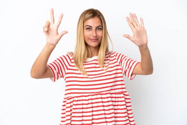 Sarışın Uruguaylı kız beyaz arka planda izole edilmiş, parmaklarıyla sekiz kişi sayıyor.