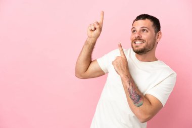 Pembe arka planda izole edilmiş genç Brezilyalı adam işaret parmağıyla işaret etmek harika bir fikir.