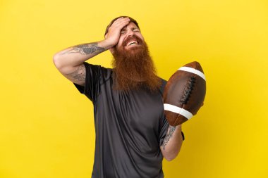 Kızıl saçlı beyaz adam sarı arka planda ragbi oynuyor. 