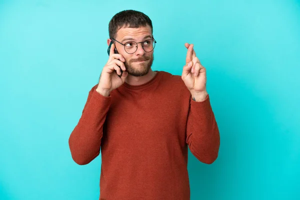 Young Brazilian Man Using Mobile Phone Isolated Blue Background Fingers — Stock Photo, Image