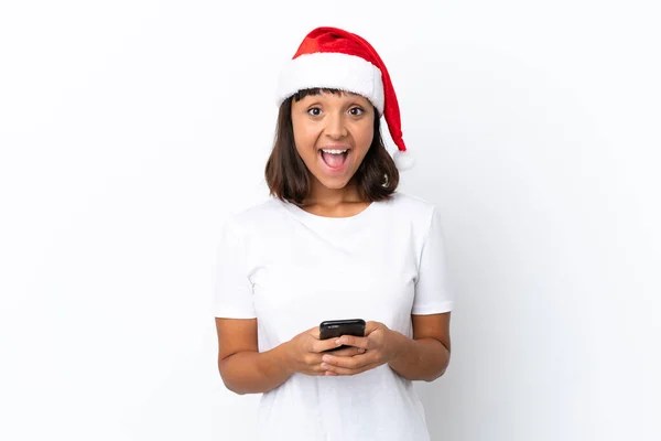 白い背景に隔離されたクリスマスを祝う若い混合人種の女性は驚いてメッセージを送ります — ストック写真
