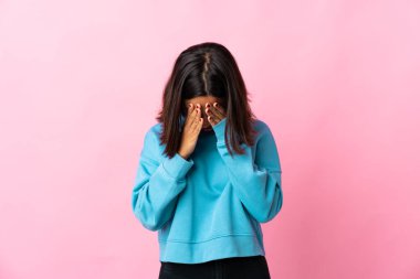 Pembe arka planda izole edilmiş genç Latin kadın yorgun ve hasta bir ifadeyle