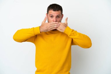 Genç Brezilyalı bir adam beyaz arka planda izole edilmiş. Ağzı elleri ile kapatıyor.