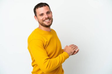 Genç Brezilyalı adam beyaz arka planda izole edilmiş alkışlıyor.