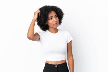 Genç Afrikalı Amerikalı kadın beyaz arka planda izole edilmiş. Kafası kaşınırken şüpheleri var.