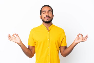 Genç Ekvadorlu adam Zen pozunda beyaz arka planda izole edilmiş.