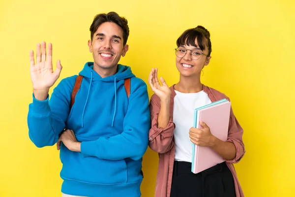 Junges Studentenpaar Auf Gelbem Hintergrund Salutiert Mit Fröhlicher Miene Der — Stockfoto