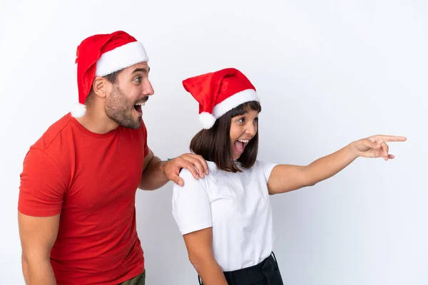 Junges Paar Mit Weihnachtsmütze Isoliert Auf Weißem Hintergrund Präsentiert Eine — Stockfoto