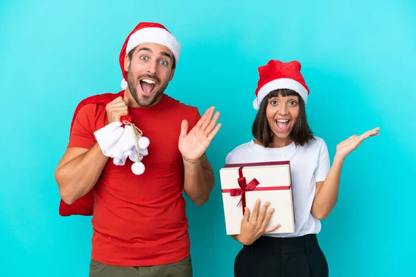 Pareja Joven Con Sombrero Navidad Repartiendo Regalos Aislados Sobre Fondo —  Fotos de Stock