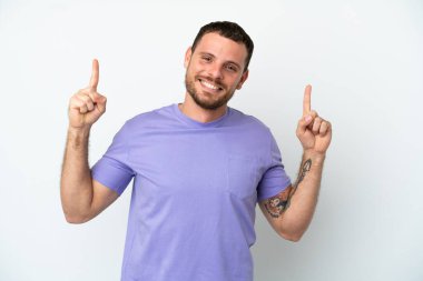 Beyaz arka planda izole edilmiş genç Brezilyalı adam harika bir fikre işaret ediyor.