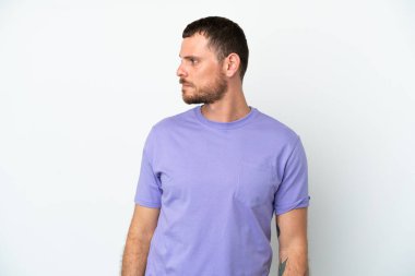 Beyaz arka planda izole edilmiş genç Brezilyalı adam yan tarafa bakıyor.