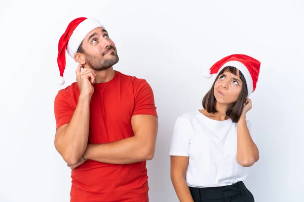 Junges Paar Mit Weihnachtsmütze Isoliert Auf Weißem Hintergrund Denkt Beim — Stockfoto