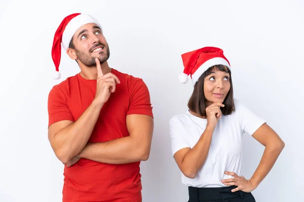 Junges Paar Mit Weihnachtsmütze Isoliert Auf Weißem Hintergrund Beim Nachdenken — Stockfoto