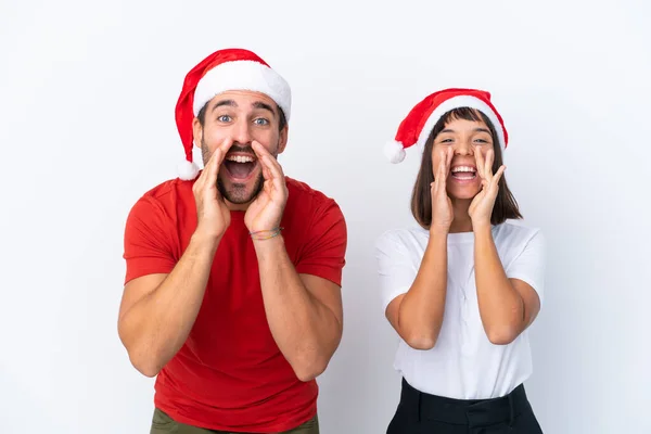 Junges Paar Mit Weihnachtsmütze Isoliert Auf Weißem Hintergrund Schreit Und — Stockfoto
