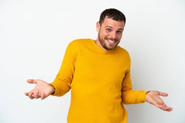 Genç Brezilyalı adam beyaz arka planda yalnız mutlu ve gülümsüyor.