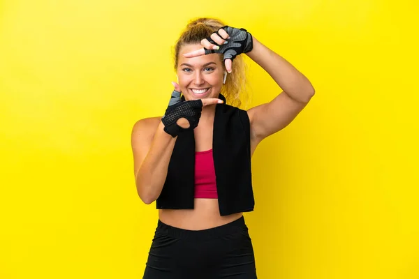 黄色の背景に焦点を当てた顔にタオルで隔離されたスポーツ女性 フレーミングシンボル — ストック写真