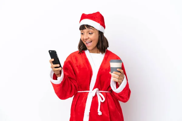 年轻的混血女子化装成圣诞老人 被白色背景隔离 手里拿着咖啡和手机 — 图库照片
