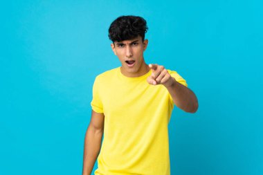 Arjantinli genç adam arka planda izole edilmiş hayal kırıklığına uğramış ve cepheyi işaret ediyor.