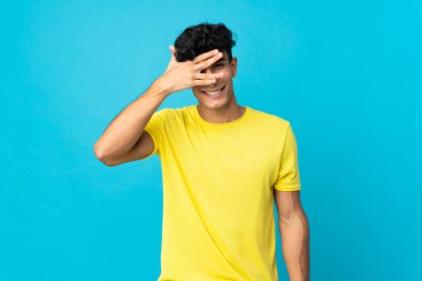 Arjantinli genç bir adam arka planda izole edilmiş, gözleri kapalı ve gülümsüyor.