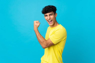 Arjantinli genç adam arka planda izole edilmiş güçlü bir jest yapıyor.
