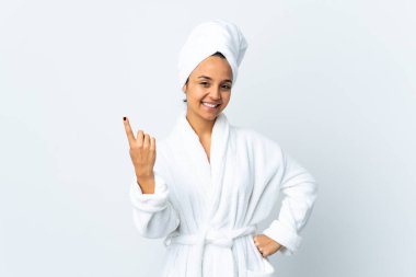 Bornozlu genç bir kadın soyutlanmış beyaz bir arka planı var.