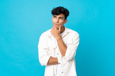 Arjantinli genç bir adam arka planda izole edilmiş. Şüpheleri ve düşünceleri var.