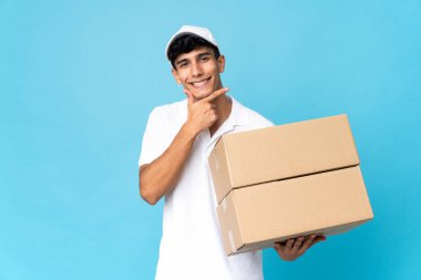 Arjantinli adam mavi arka planda izole edilmiş mutlu ve gülümsüyor.