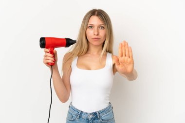 Arka planda saç kurutma makinesi olan bir kadın.