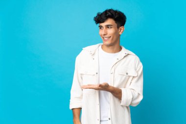 Arjantinli genç adam arka planda izole edilmiş bir şekilde bir fikir sunuyor.