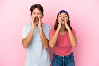 Pembe arka planda yaşayan genç bir çift bağırıyor ve bir şey duyuruyor.