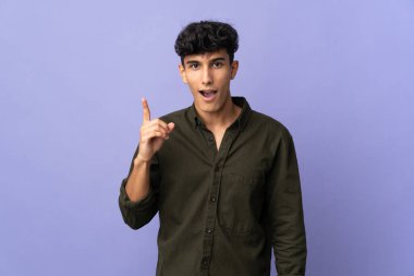 Arjantinli genç bir adam arka planda izole edilmiş bir şekilde parmağını kaldırarak çözümü anlamaya çalışıyor.