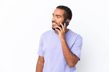 Genç Ekvador 'lu beyaz arka planda izole edilmiş bir adam cep telefonuyla sohbet ediyor.