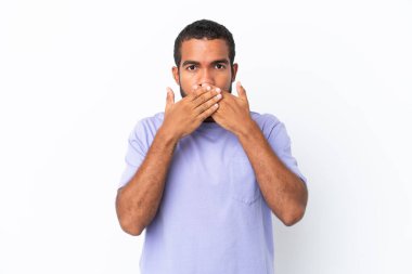 Genç Ekvadorlu adam beyaz arka planda izole edilmiş, ağzı elleriyle kapatıyor.