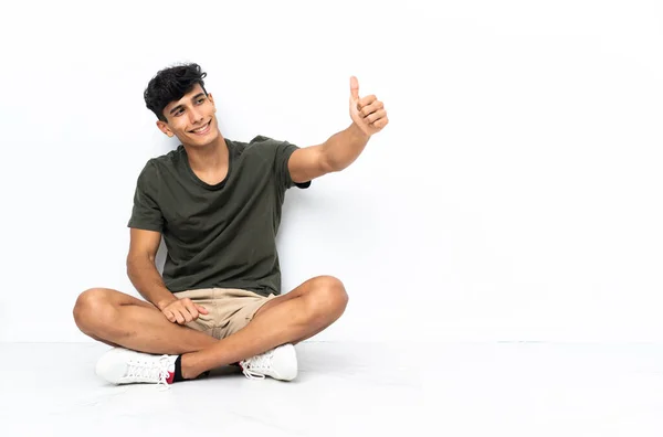 Молодой Аргентинский Мужчина Сидящий Полу Показывающий Большой Палец — стоковое фото