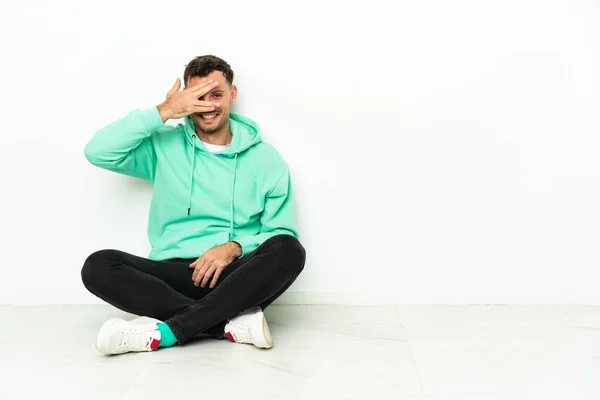 Young Handsome Caucasian Man Sitting Floor Covering Eyes Hands Smiling — Stock Photo, Image