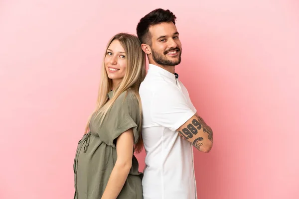 怀孕妇女和男子交叉交叉双臂 越过孤立的粉色背景 — 图库照片