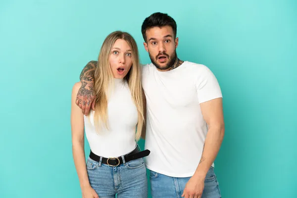 Jeune Couple Sur Fond Bleu Isolé Avec Expression Faciale Surprise — Photo