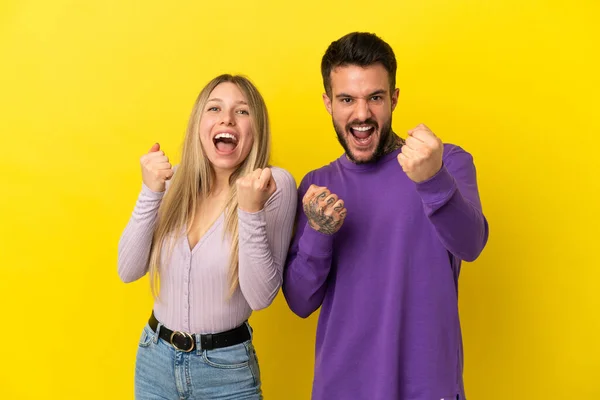 Junges Paar Vor Gelbem Hintergrund Feiert Einen Sieg — Stockfoto