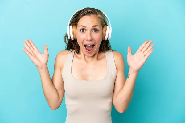 Young Caucasian Woman Isolated Blue Background Surprised Listening Music — Stock Photo, Image