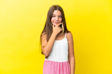 Küçük beyaz kız sarı arka planda izole edilmiş.