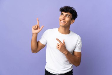 Arjantinli genç adam arka planda izole edilmiş işaret parmağıyla işaret etmek harika bir fikir.