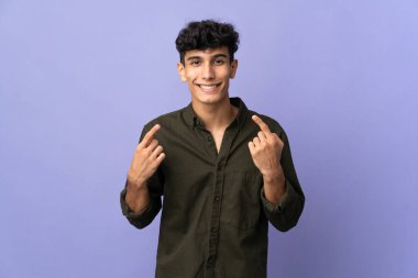 Arjantinli genç adam arka planda izole edilmiş bir şekilde baş parmak hareketi yapıyor.