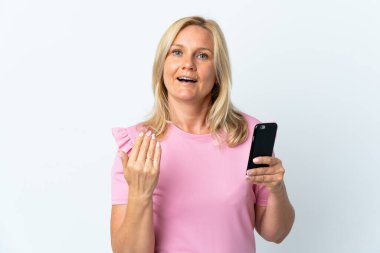 Beyaz arka planda izole edilmiş cep telefonu kullanan orta yaşlı bir kadın. Gelmene sevindim.