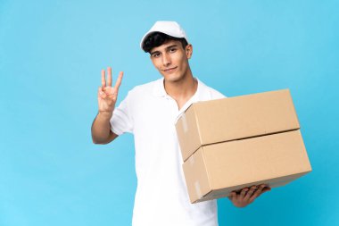 Arjantinli adam mavi arka planda izole edilmiş mutlu ve parmaklarıyla üçe kadar sayıyor.