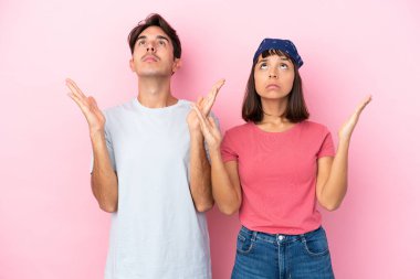 Pembe arka planda izole edilmiş genç çift kötü bir durum yüzünden hayal kırıklığına uğradı.