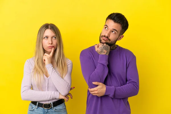 Young Couple Isolated Yellow Background Standing Thinking Idea — Stock Photo, Image