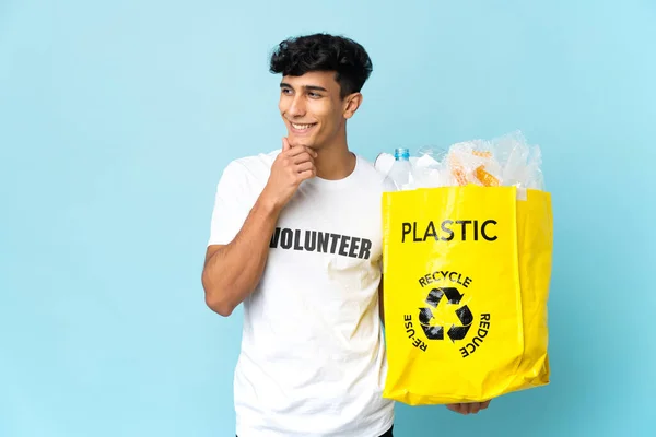 Joven Argentino Sosteniendo Una Bolsa Llena Plástico Mirando Lado Sonriendo — Foto de Stock