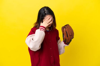 Beyzbol eldivenli genç Vietnamlı kadın yorgun ve hasta bir ifadeyle sarı arka planda izole edilmiş.