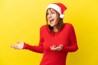 Kızıl saçlı kız, sarı arka planda izole edilmiş. Sürpriz bir ifadeyle yan tarafa bakıyor.