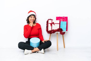 Genç bir kız Noel 'i kutluyor. Yerde izole bir şekilde oturuyor.